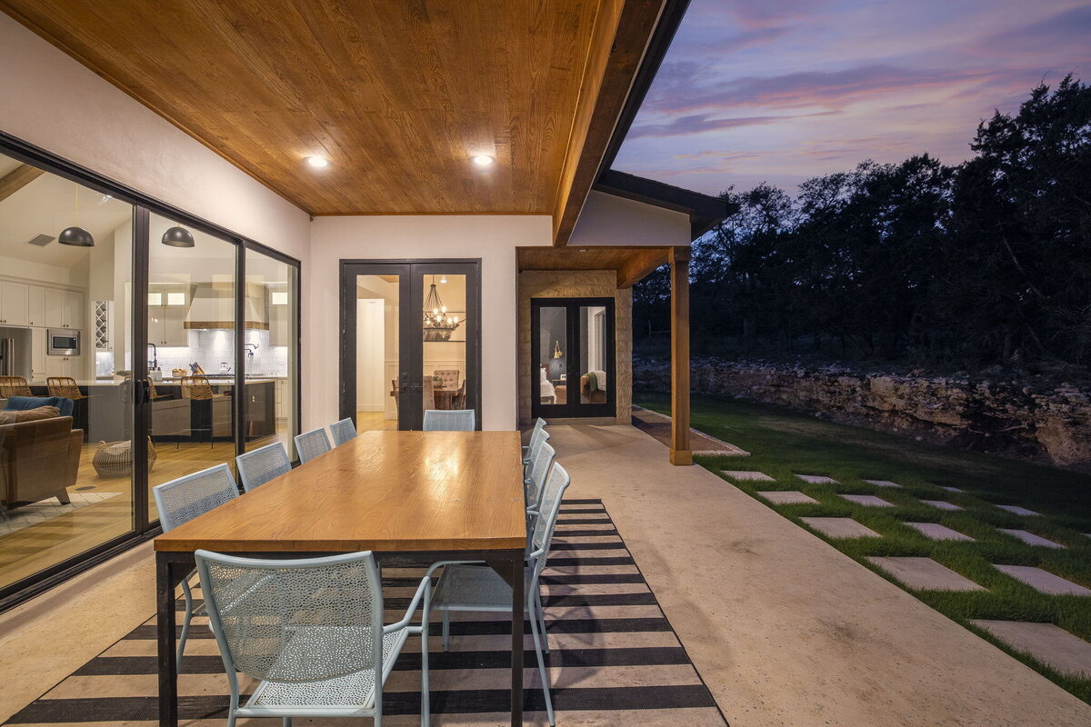 dining area in back porch with wood ceiling overhang and large windows