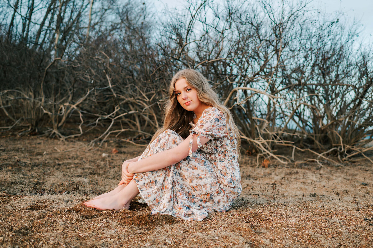 senior girl sitting in sand  during Branson senior photography session