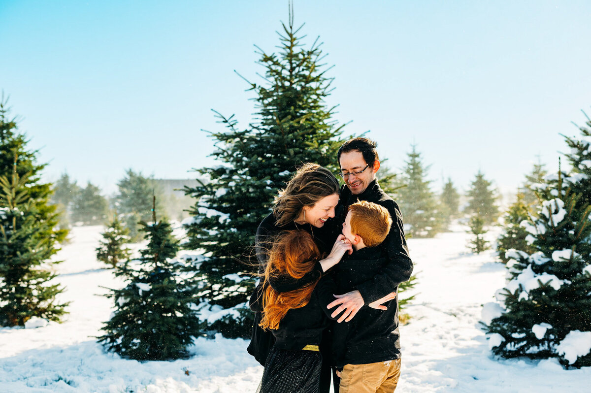 Family posing together at Christmas tree farm during Ottawa holiday mini session.