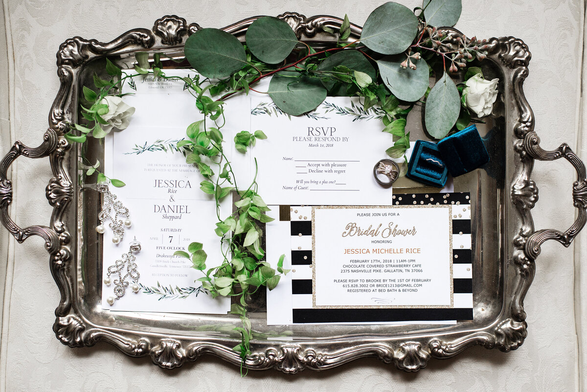 Brides details paired with wedding invitations on a vintage tray