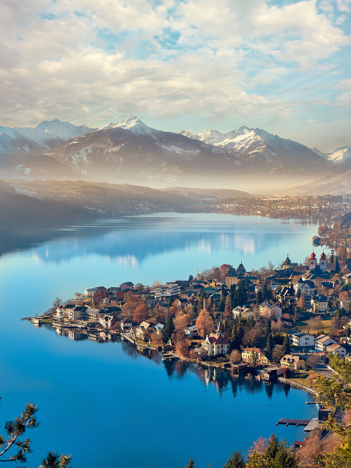Stimmungsvolle Winteraufnahme des Millstätter Sees mit Blick auf verschneite Alpen im Hintergrund – fotografiert vom Spezialisten für Alpenlandschaften, Atelier Schulte, Kärnten