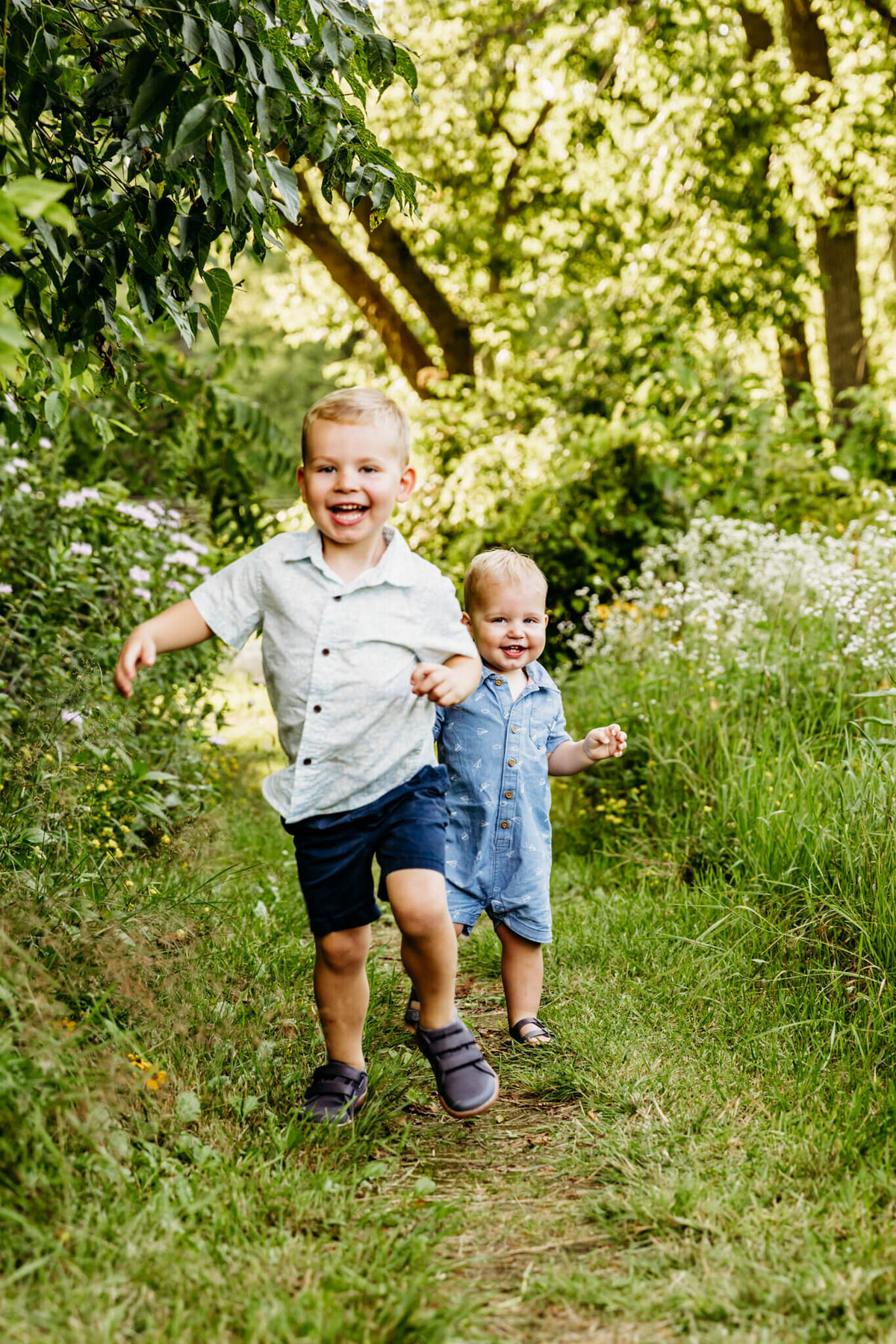 two young boys running in a pathway together captured by Ashley Kalbus Photography