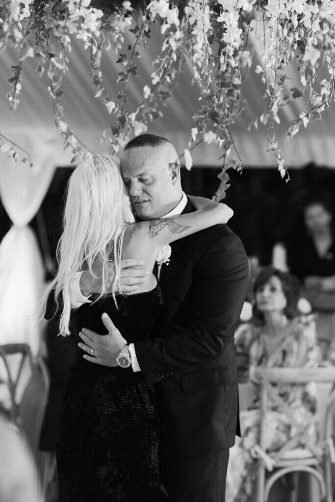 A touching moment as the groom shares a dance with his mother, celebrating love and family under a canopy of lights and florals. Florida Keys wedding photography by Claudia Amalia Photography.