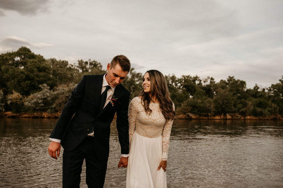 bride and groom walking through Rio Grande river