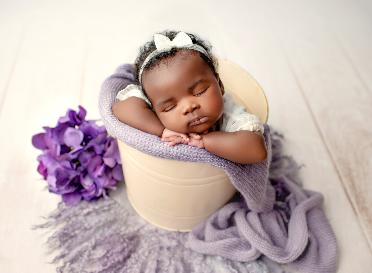 Baby in a basket with violet blanket