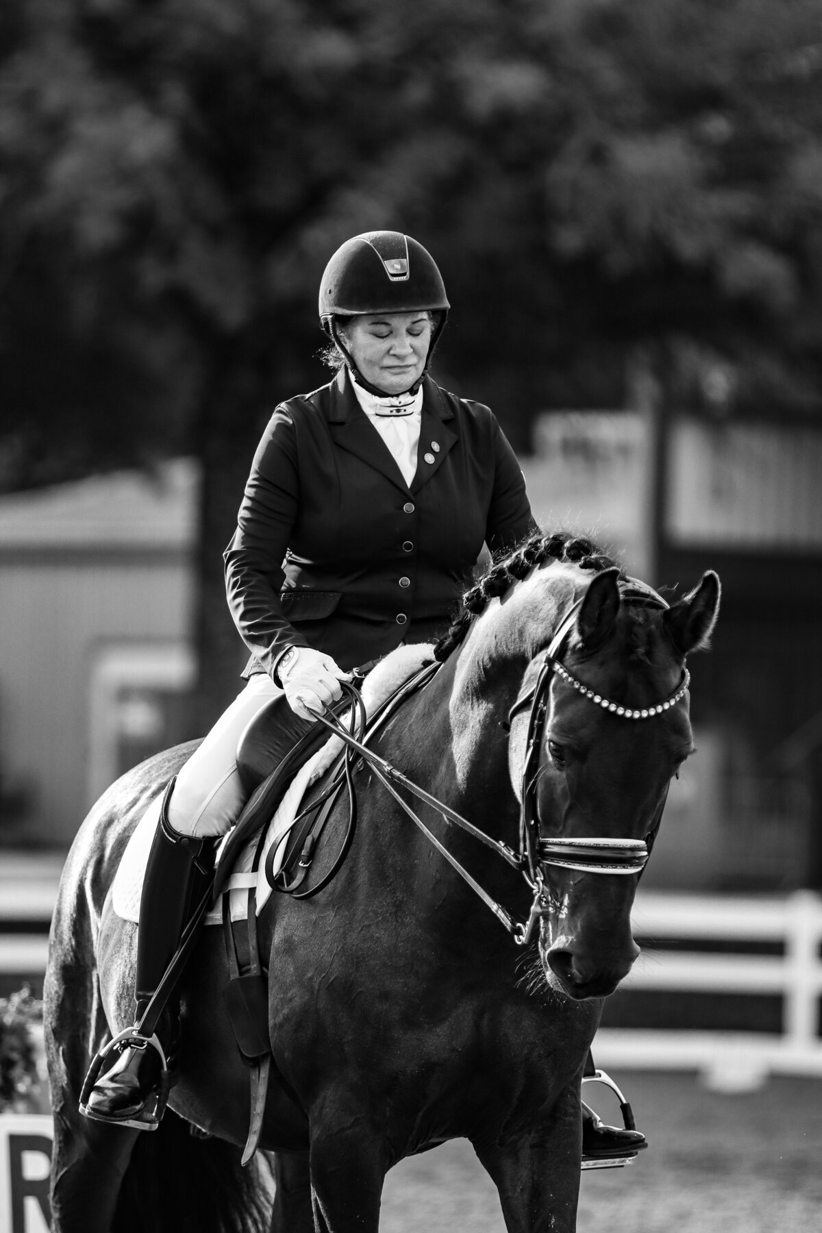 A black and white photo of a rider looking down at their horse before a dressage test in Conyers, Georgia.