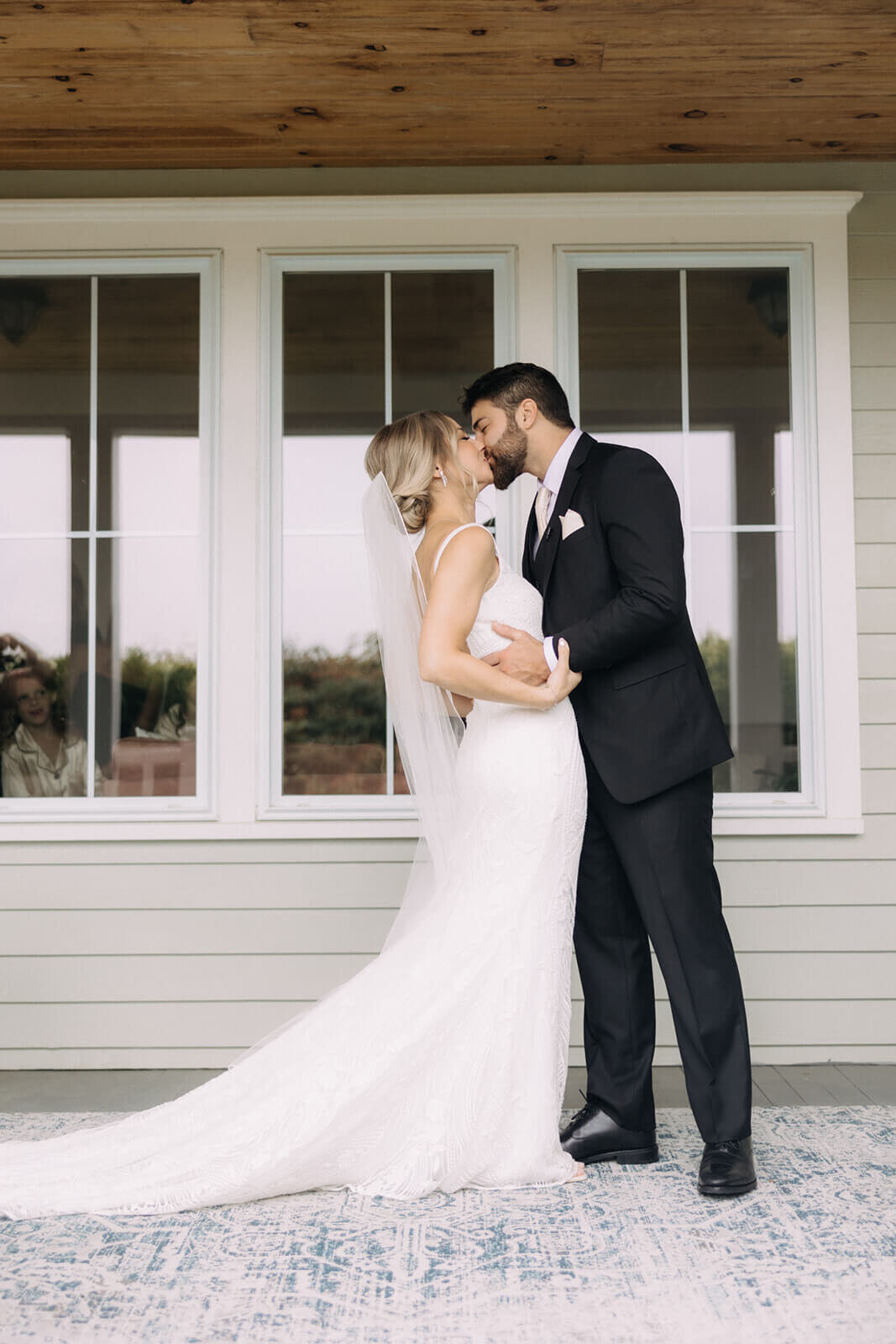 Bride and groom kissing on porch before wedding