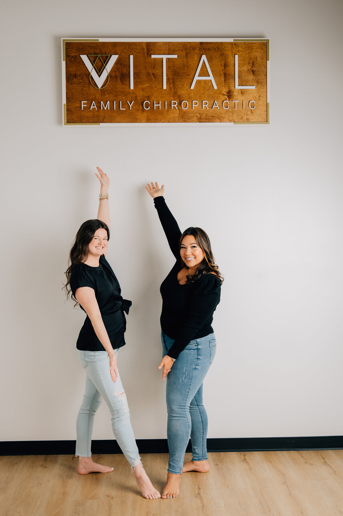 Two team members striking playful poses in branded clinic photo session