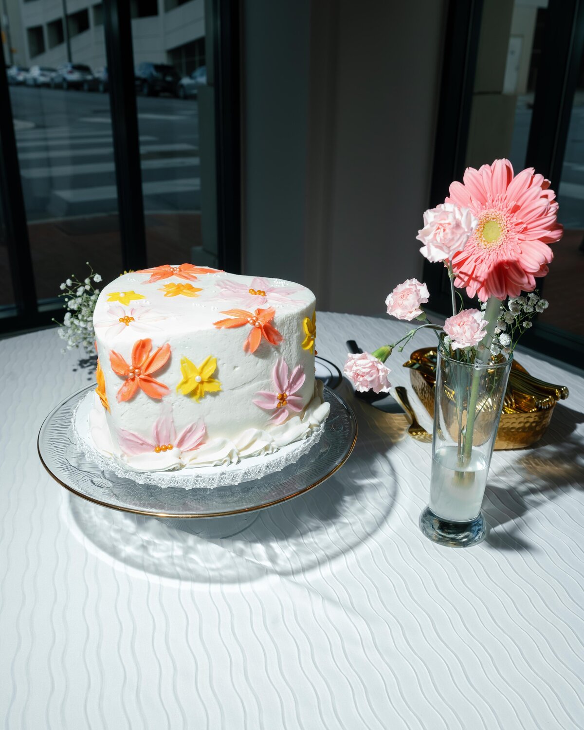 A colorful wedding cake with orange, yellow, and pink flowers