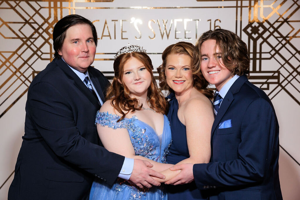 Sweet 16 family portrait in front of Great Gatsby red carpet step and repeat