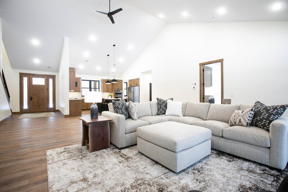 Cozy living room in Elk River custom home with fireplace, built-ins, and large windows