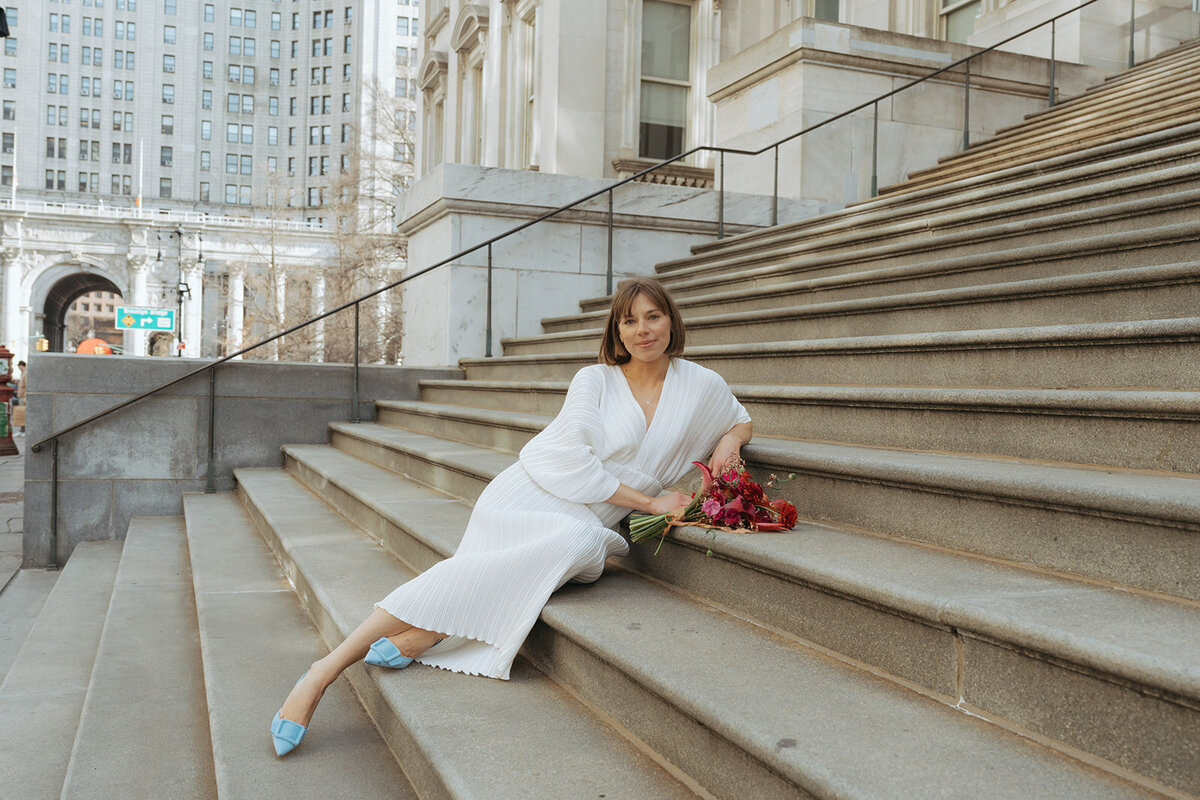 bride on steps outside NY City Hall after eloping shot by Elsie Goodman Photography | NYC Elopement Packages