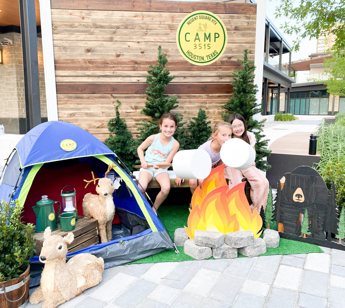 Kids posing in a camping outdoor themed corporate event backdrop design
