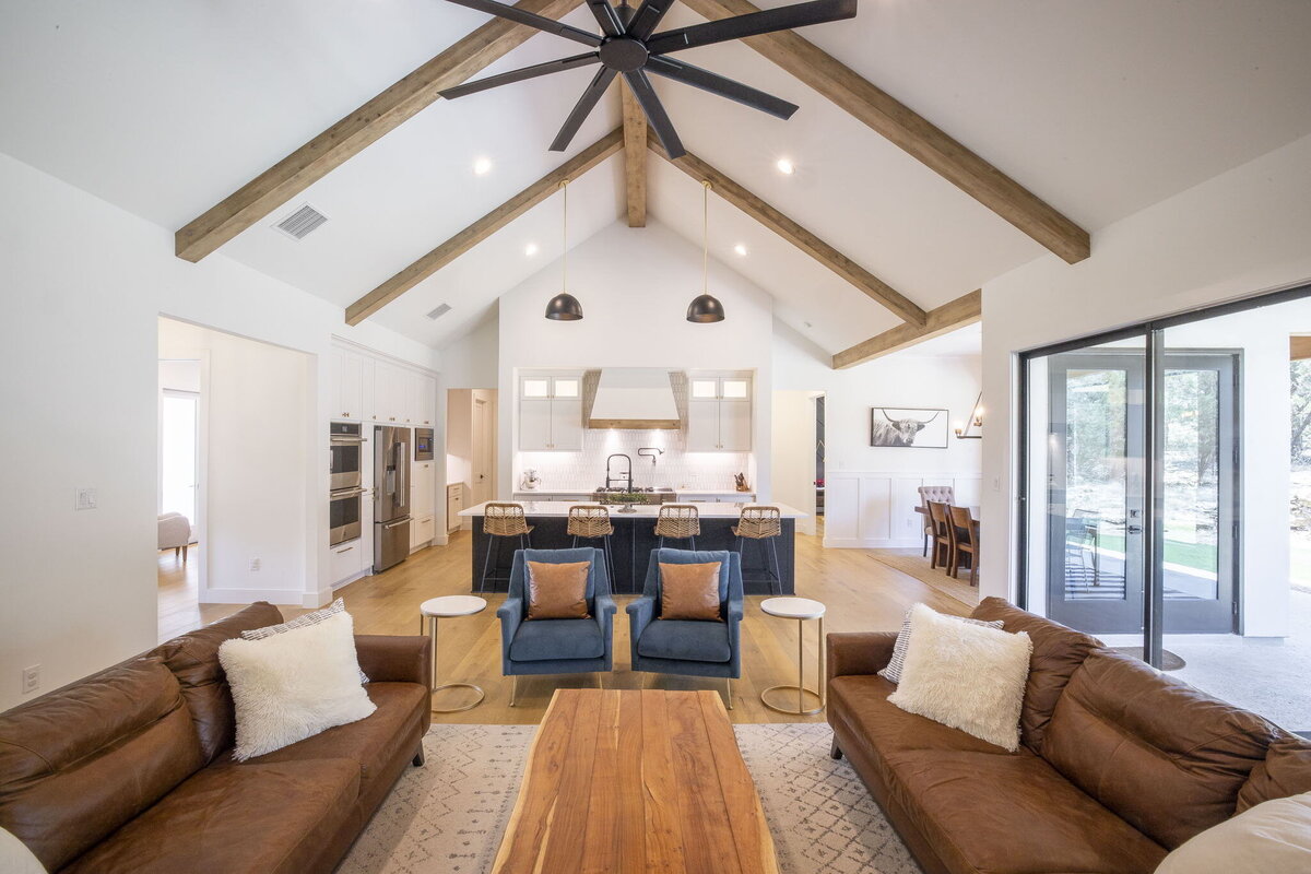 open concept living room and kitchen with vaulted ceiling and wood beams