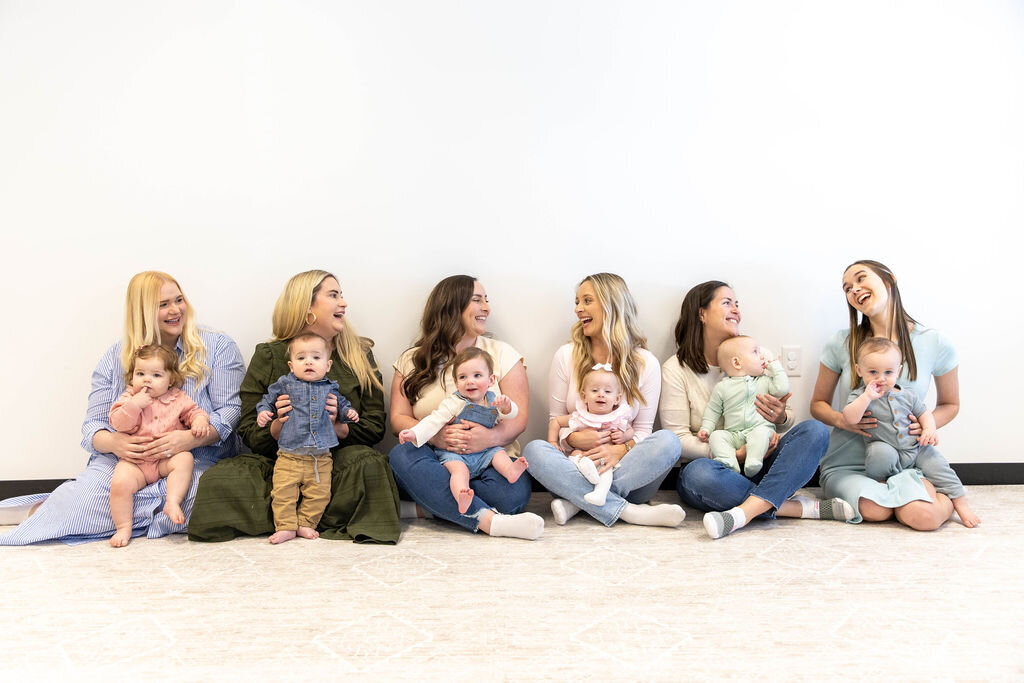 Group of women smiling, holding their babies