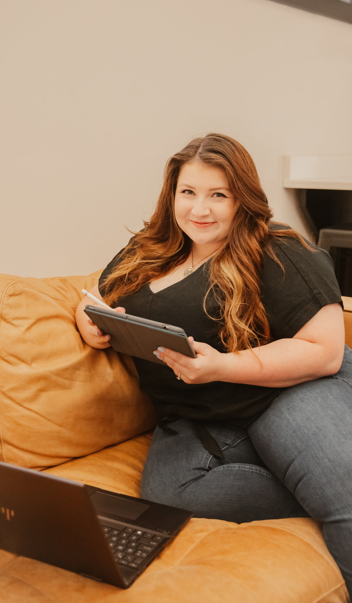 Madeline Murdock, owner of Mad Impact Design, typing on laptop