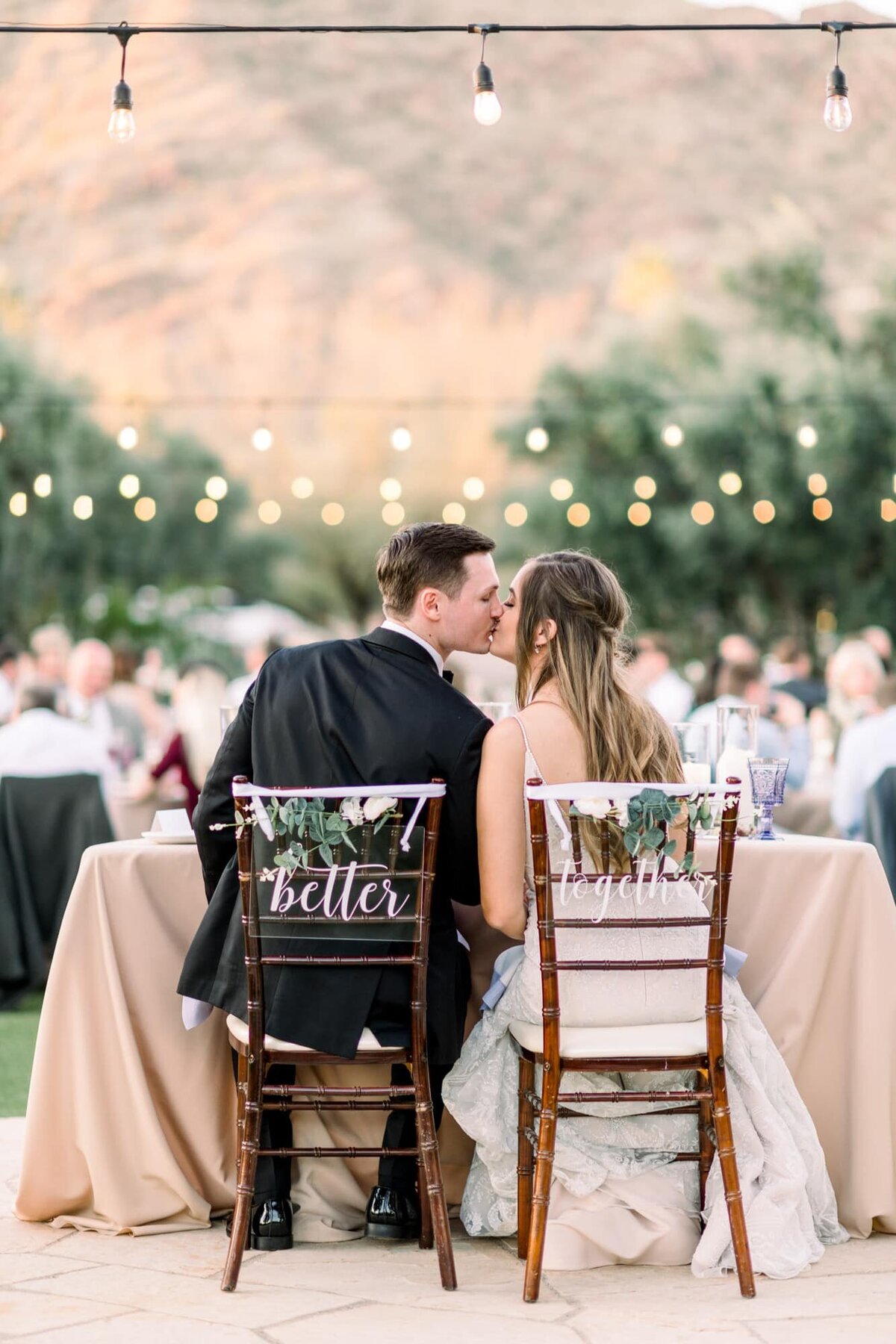 Bride kissing Groom at table during reception on the Event Lawn at El Chorro