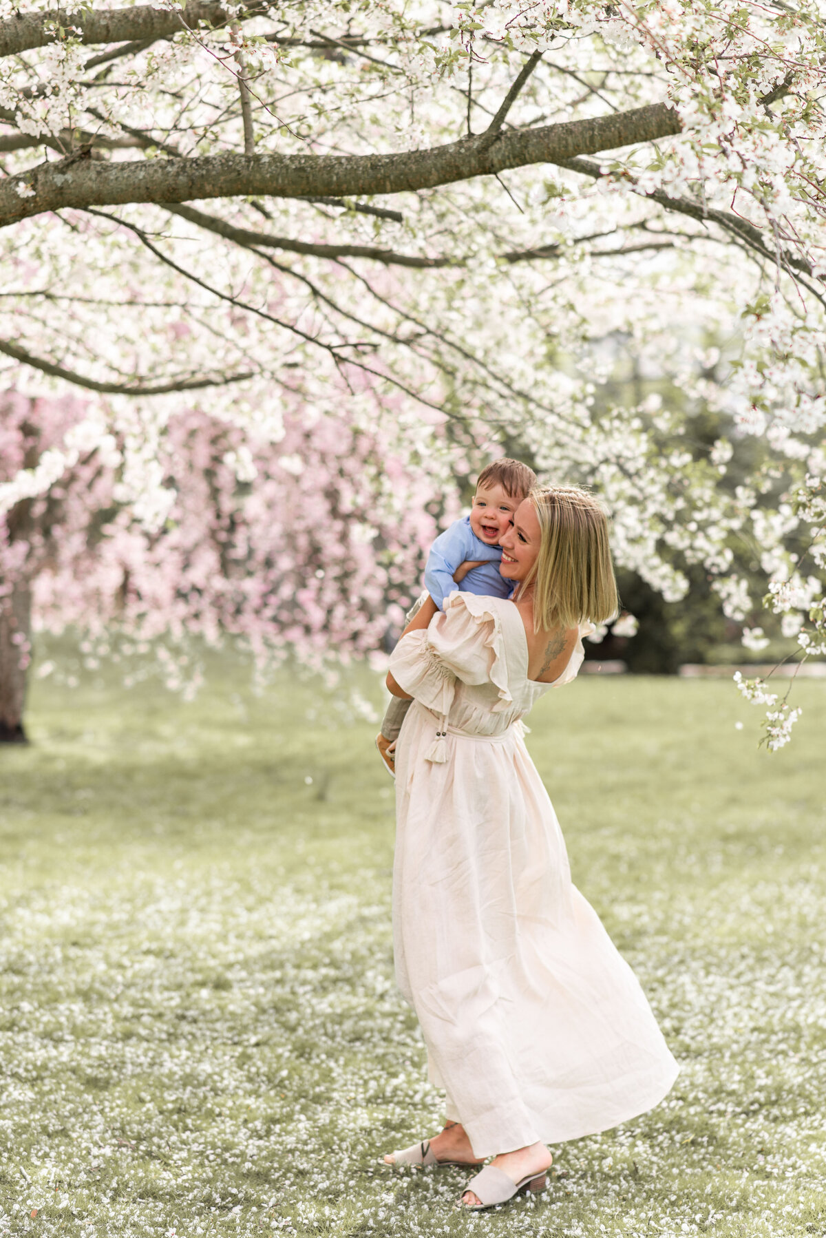 Mom and son lifestyle portrait outdoors in the spring wearing white dress and blue shirt