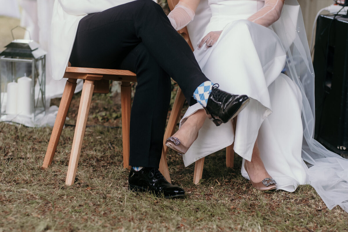 Das Hochzeitspaar sitzt mit überkreuzten Beinen nebeneinander während der freien Trauung.