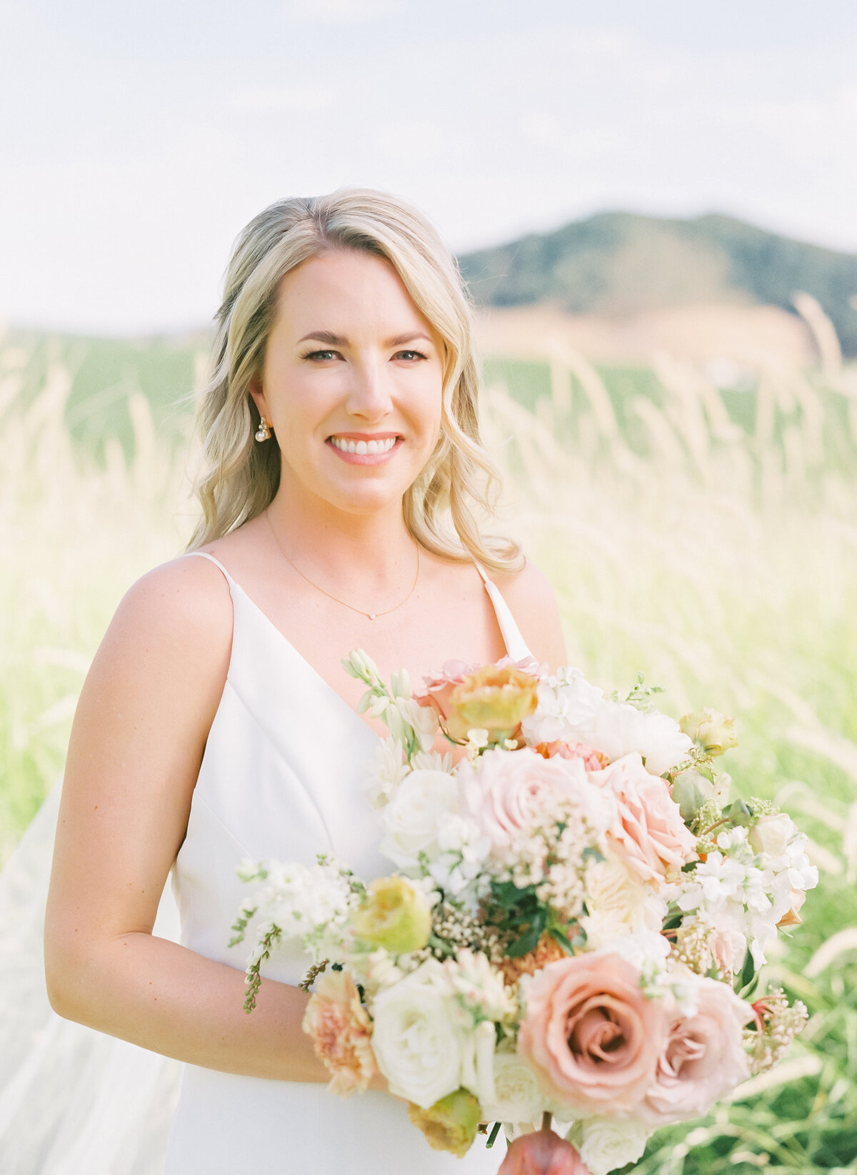 bride holding bouquet smiling at camera