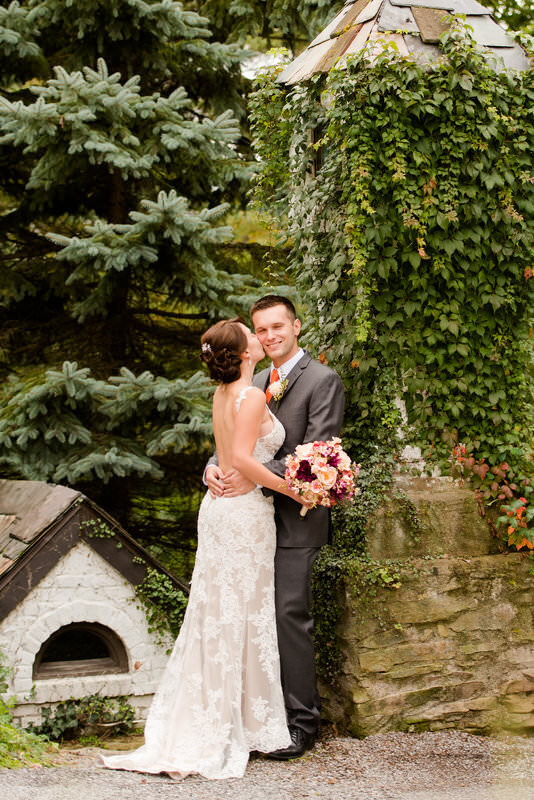 bride kissing the groom cheek at the Hyeholde restaurant wedding venue
