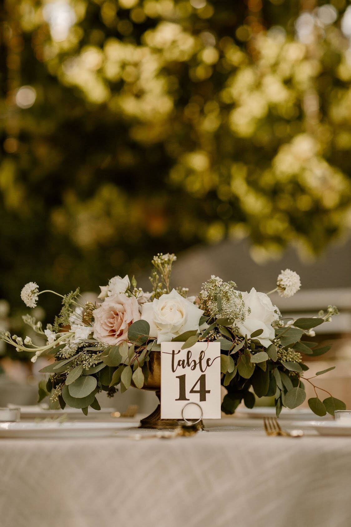 Blush and white roses with seeded and silver dollar eucalyptus is a perfect centerpiece.