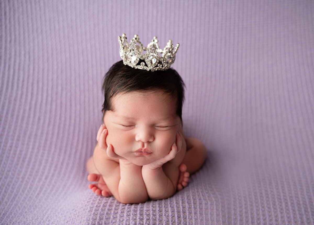 newborn girl in frog pose with tiara