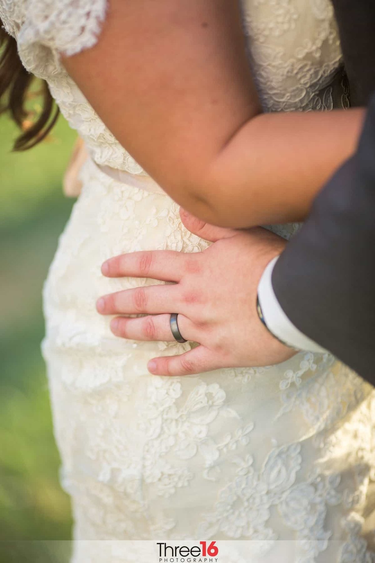 Groom's ring shines as they embrace each other