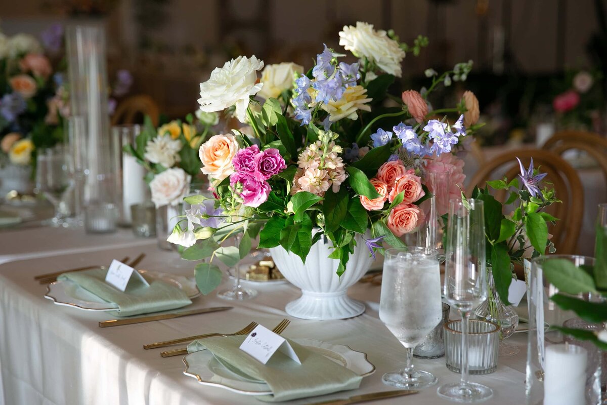 Close-up of spring floral centerpiece and table décor at Merrimon-Wynne House wedding reception.
