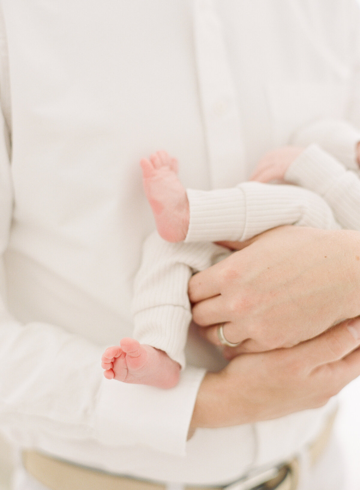 Dad holding baby toes during an Apex newborn session. Photographed by Raleigh Newborn Photographer A.J. Dunlap Photography.