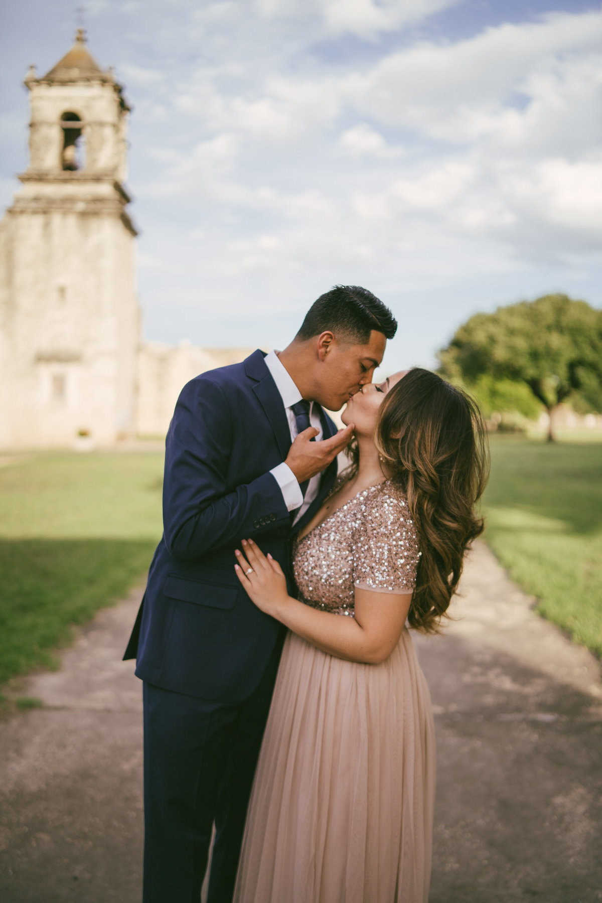 Fiancé pulling in his fiancée for a kiss at Mission San Jose in San Antonio.