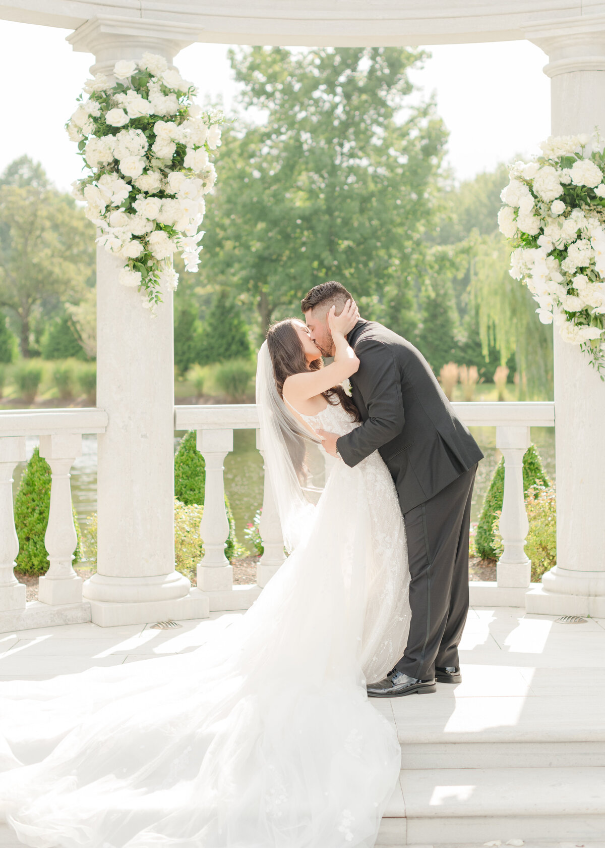 couple-first-kiss-at-wedding-arch-574