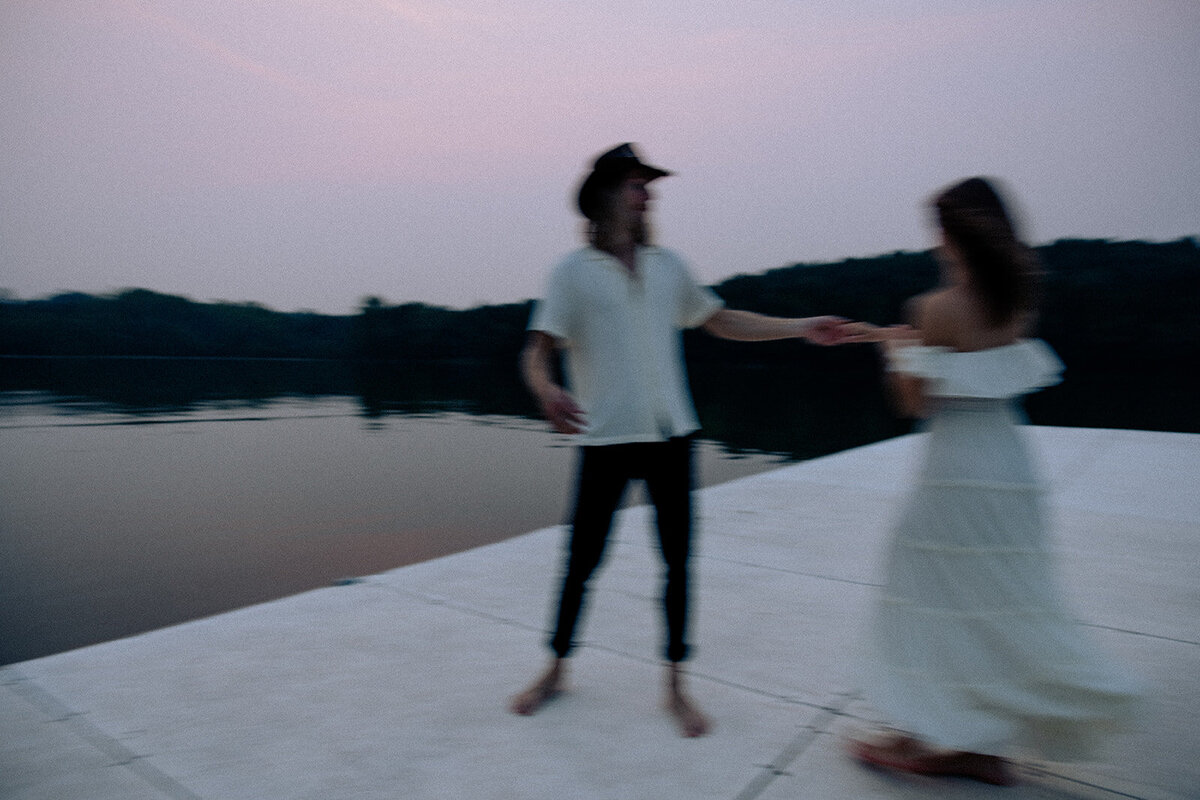 Couple dances together in hazy blur on a dock surrounded by lake water at Percy Priest Lake.