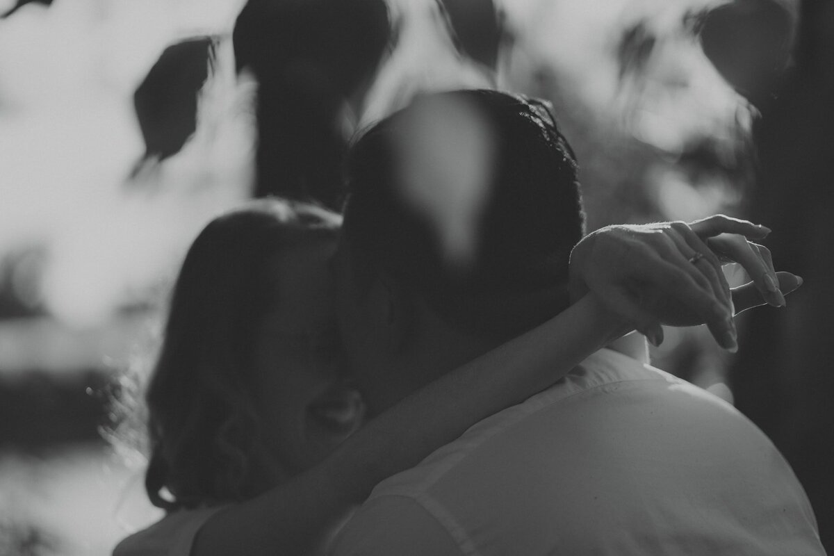 Man kisses woman on forehead in front of trees in Calgary