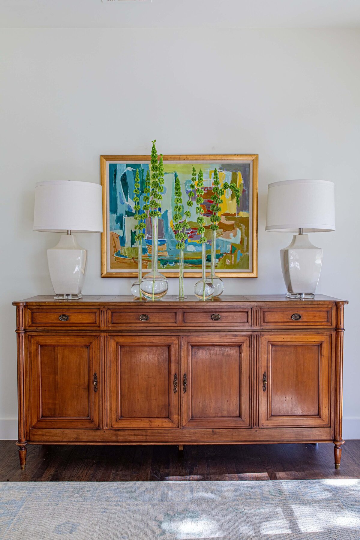 oyster creek studios highland park home painting on wooden cabinet with two white accent lamps