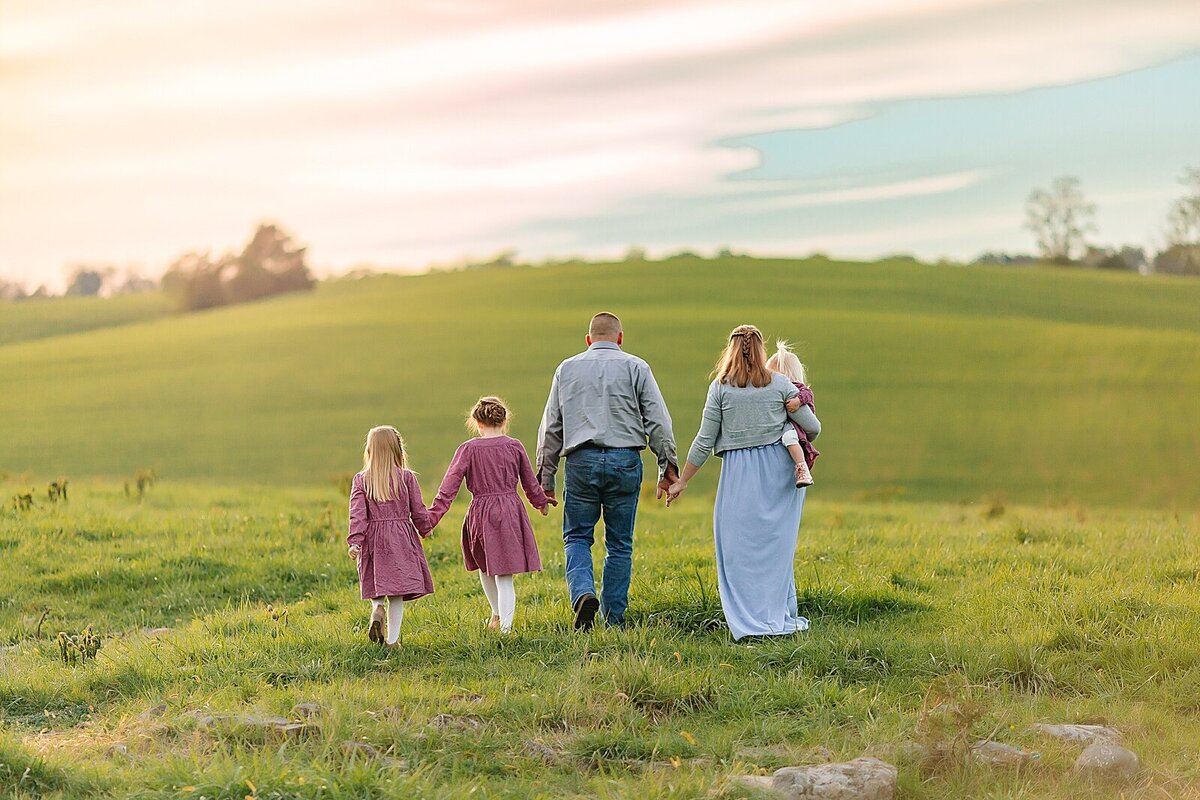 Family walking in a field at sunset in Harrisonburg, VA