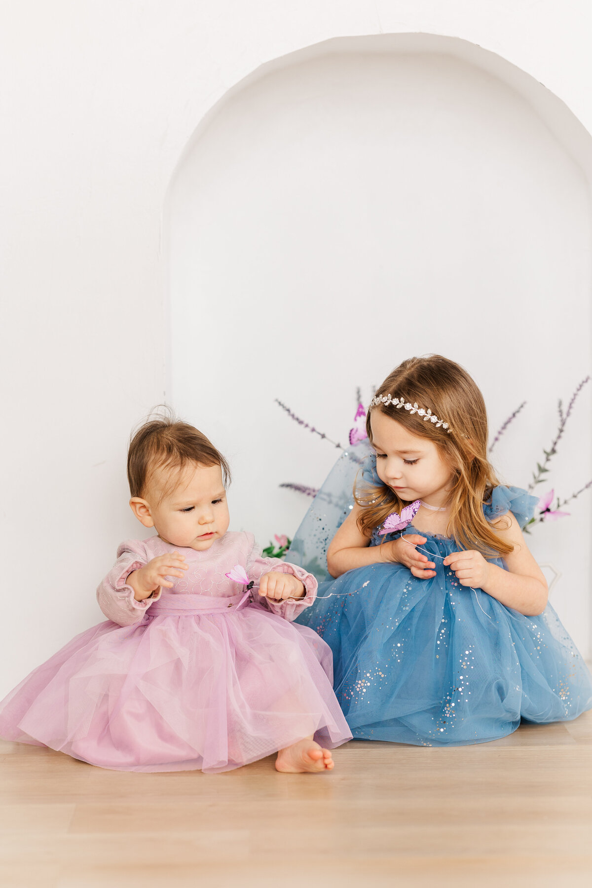 1-year-ole-and-three-year-old-sisters-in-pink-and-blue-tulle-dresses-taken-at-the-Lumen-Room-Dallas