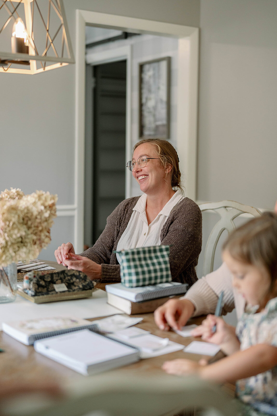 Woman sitting at a dining table working with planners during the Indiana branding photo session.