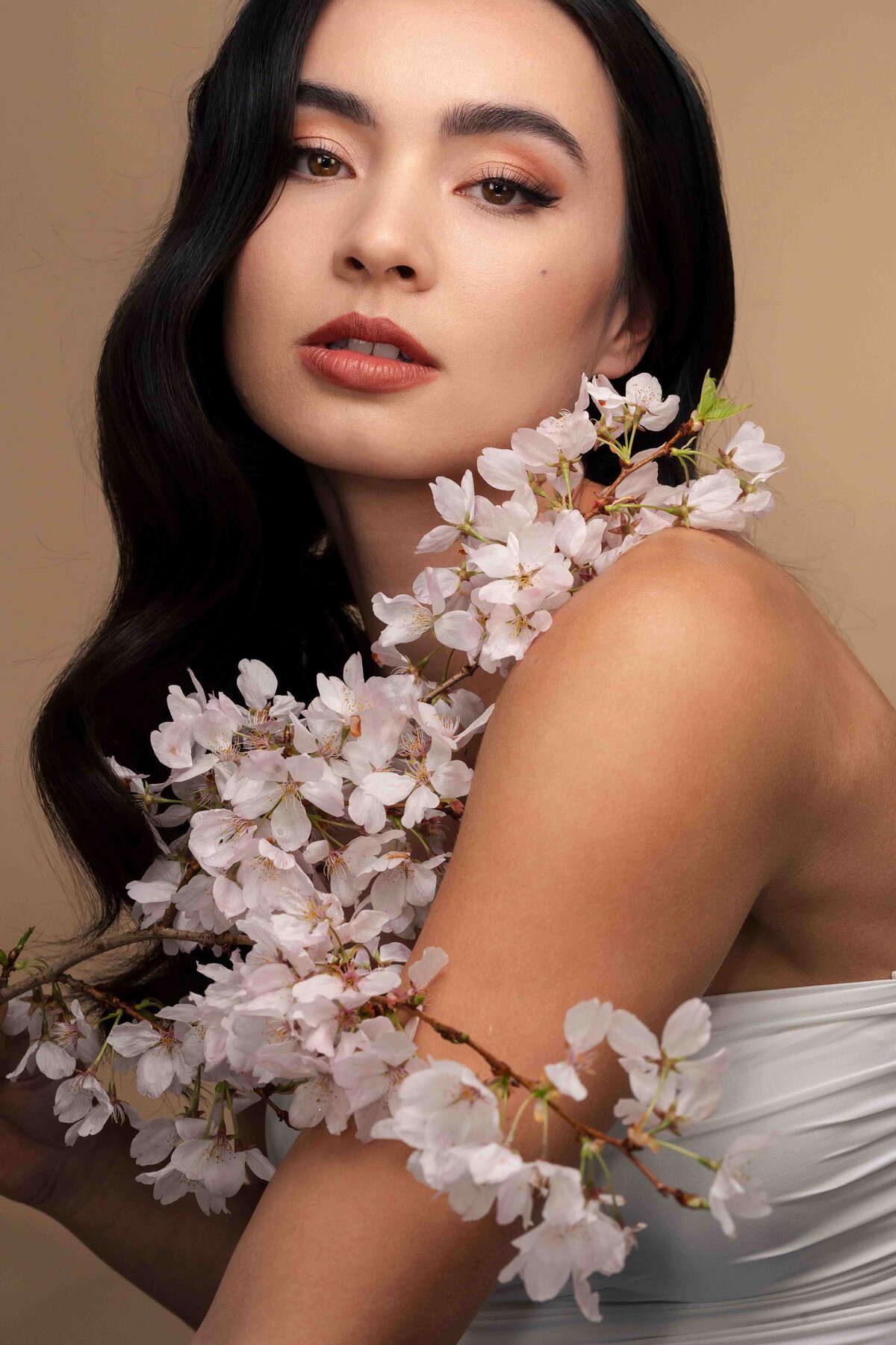 model posing with cherry blossom branch