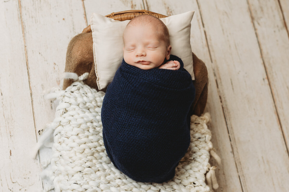 swaddled baby boy on boho bed by harrisburg pa newborn photographer