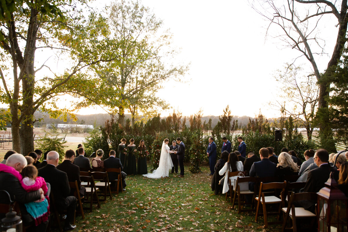 Bride and groom praying  at their wedding ceremony at a vineyard in the fall by Kansas City wedding photographer, Caia Grace