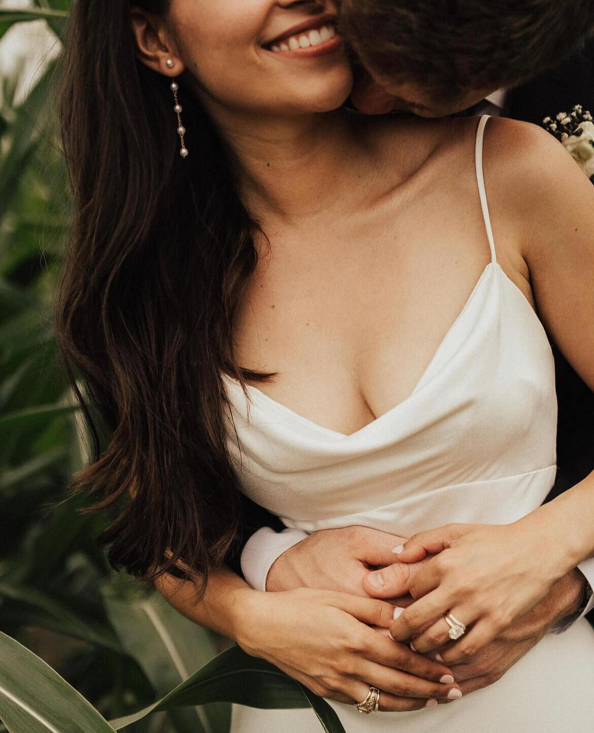 Close-up of bride with professional bridal makeup and long dark curls, embraced during romantic Austin wedding day