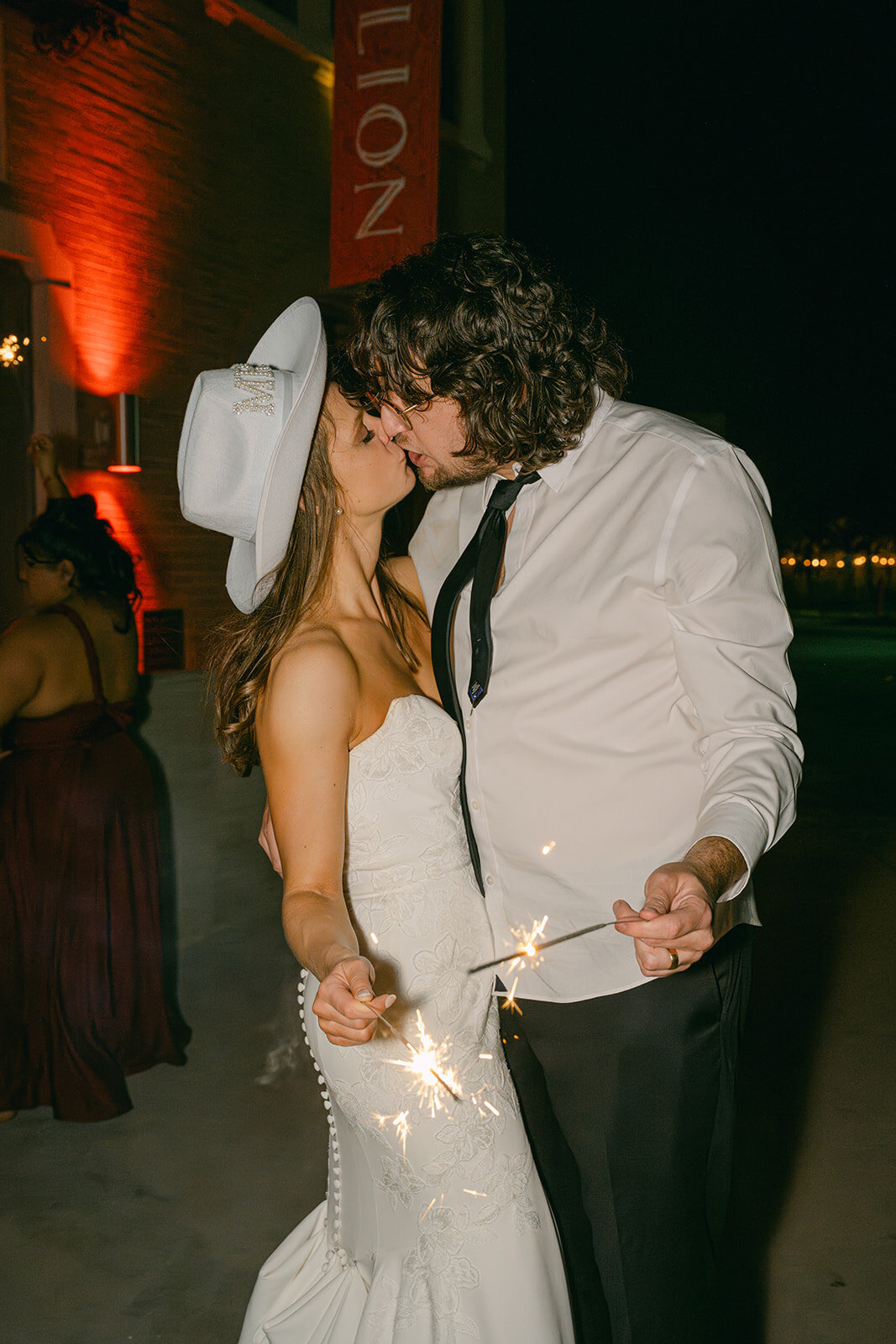 Groom escorting bride through nighttime sparkler exit at The Battalion