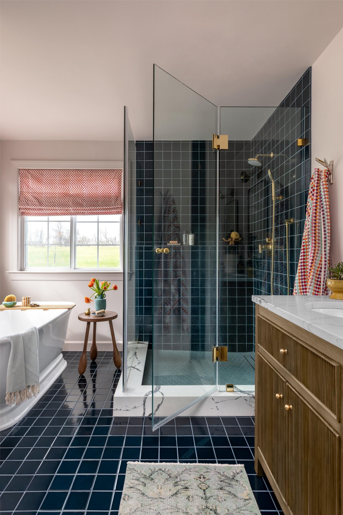 Primary bathroom remodel with blue-green glossy shower tile and brass fixtures

