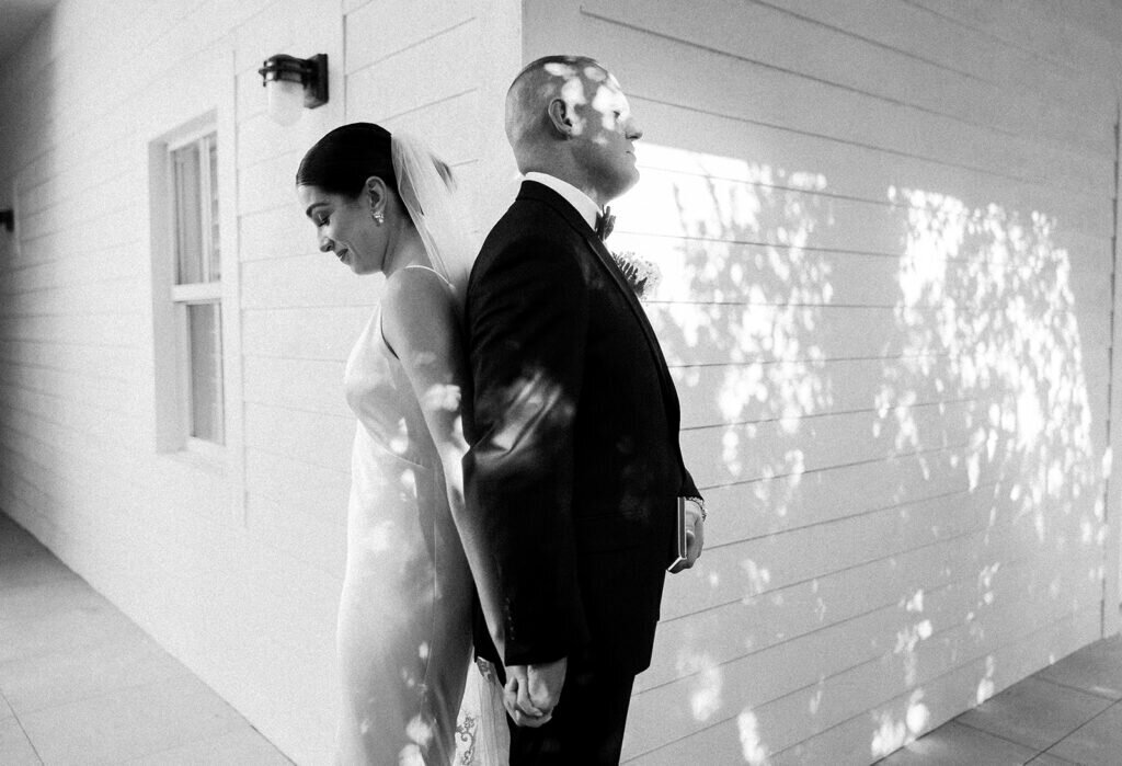 Also a black and white portrait of the bride and groom holding hands before their wedding, feeling the moment before seeing each other. Destination wedding photography by Claudia Amalia Photography in the Florida Keys.