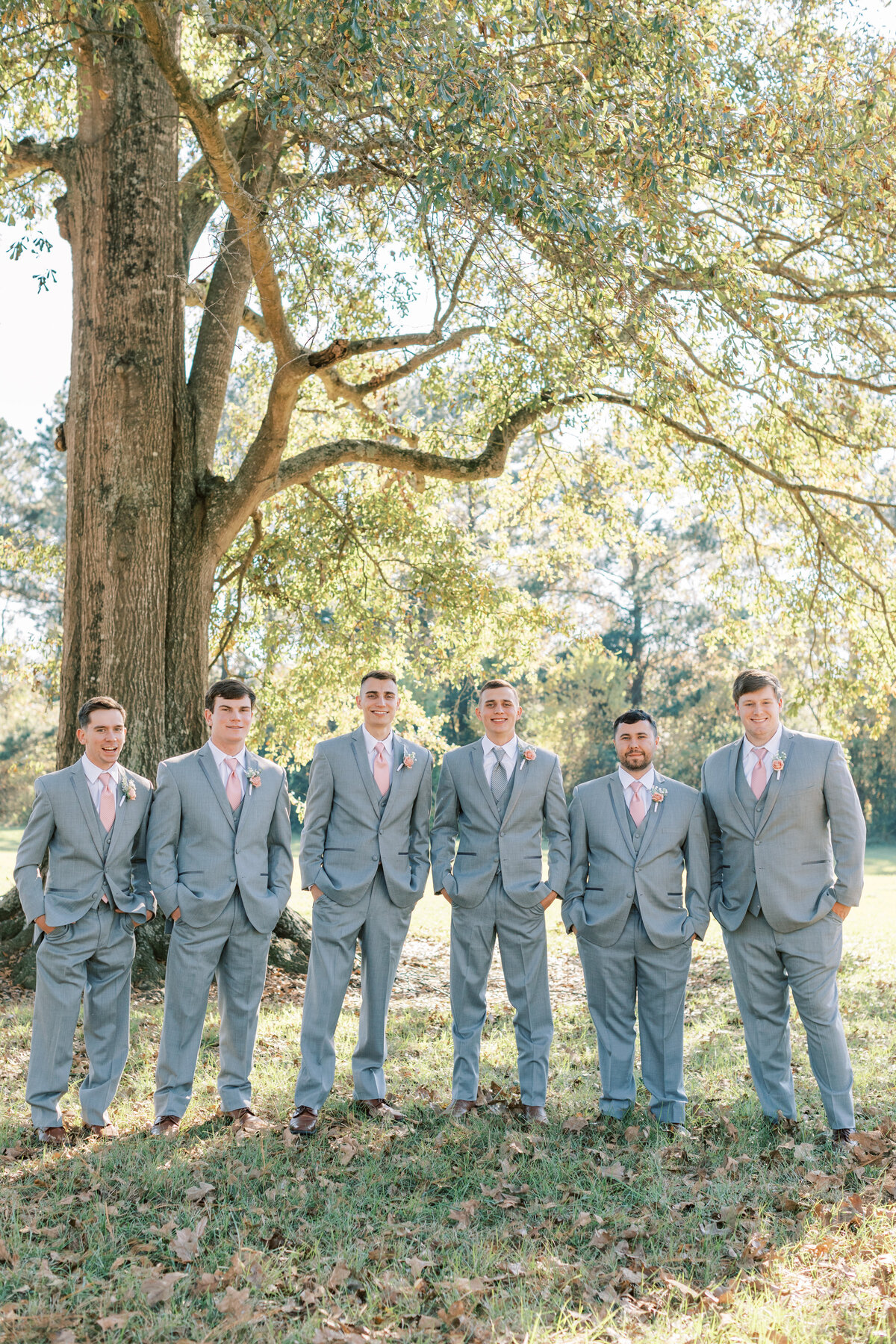 A groom stands with the groomsmen.