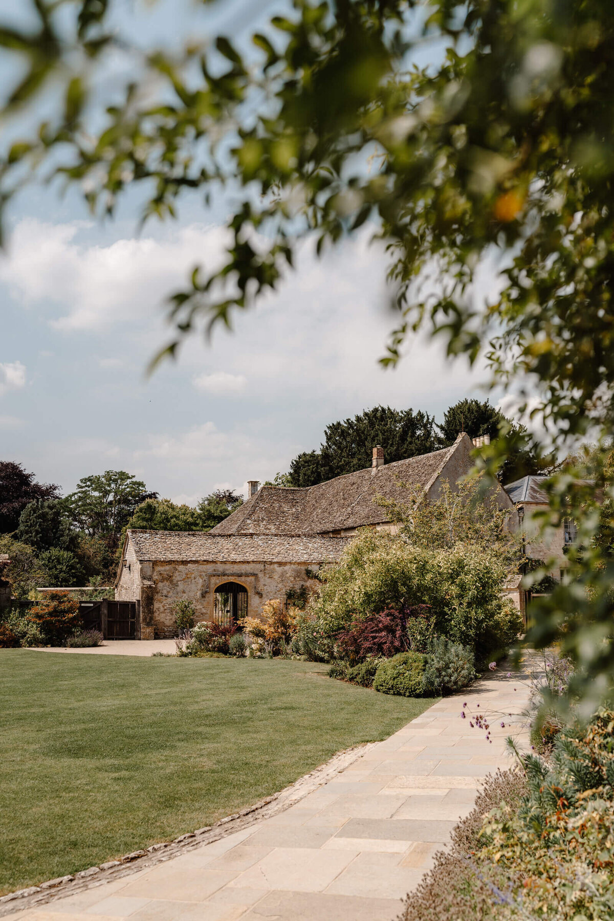 Caswell House exterior in bright sunshine with views of the manicured gardens