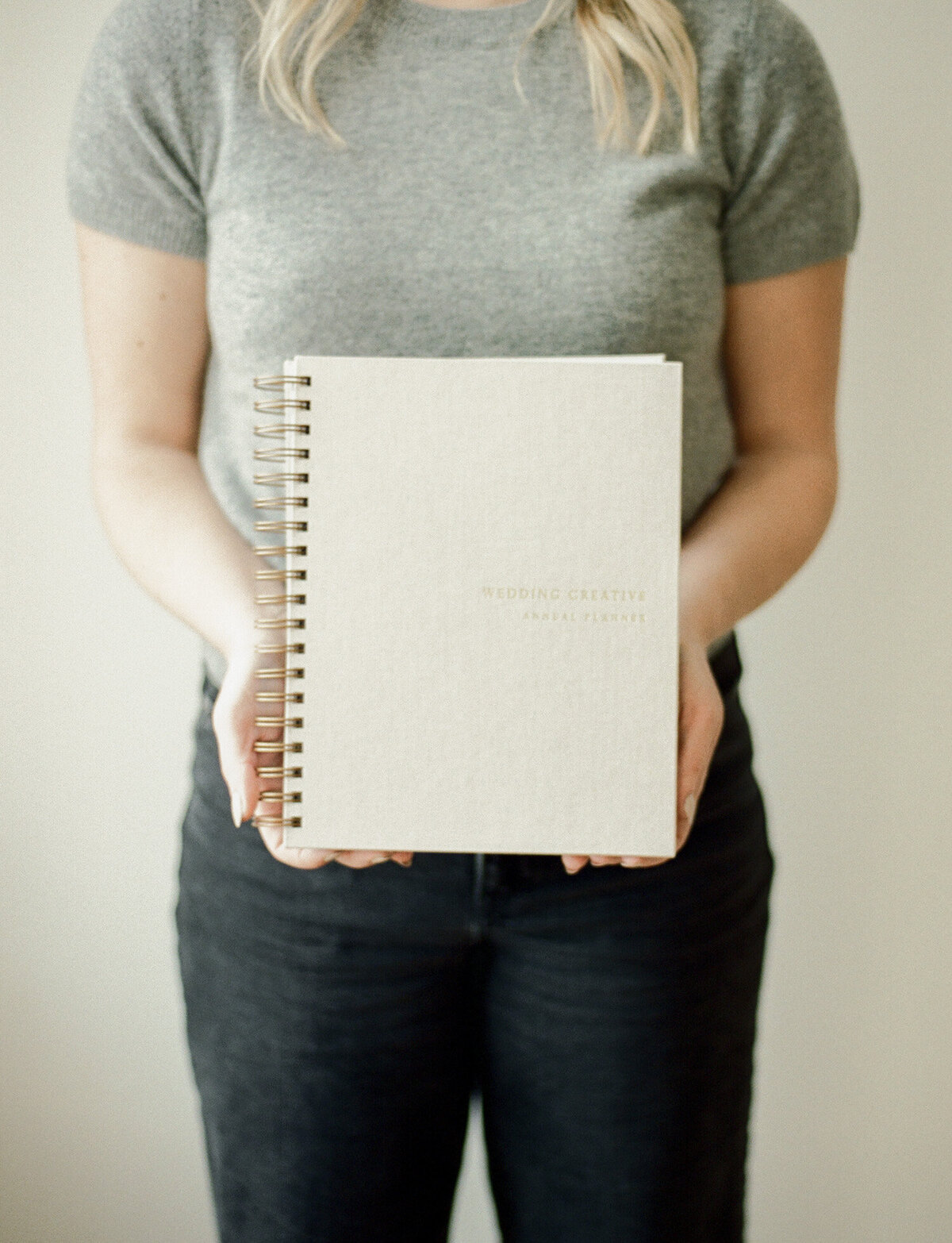 woman holds beige linen planner for product photography, film branding photography