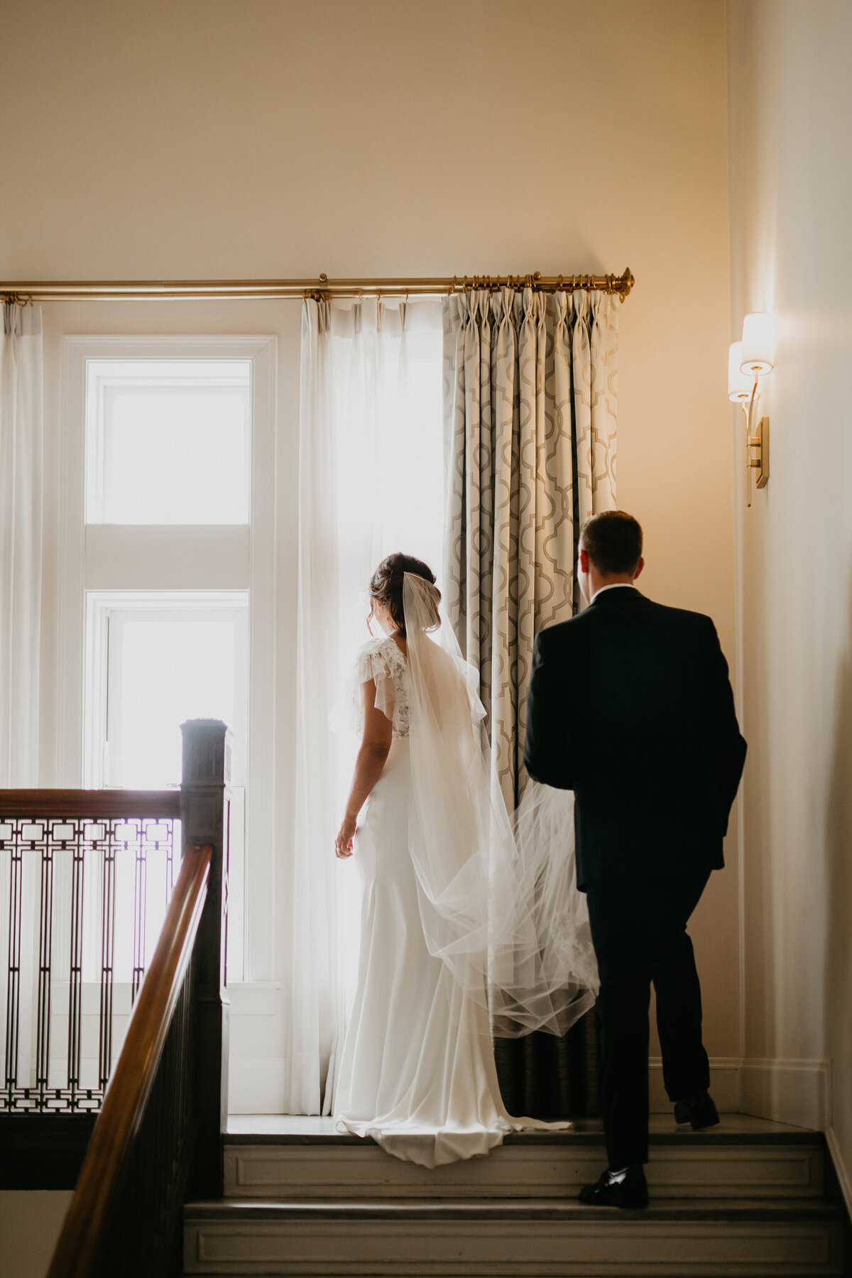 Bride and groom walking up an romantic staircase captured by Nikki Collette Photography, adventurous and romantic wedding photographer in Red Deer, Alberta. Featured on the Bronte Bride Vendor Guide.