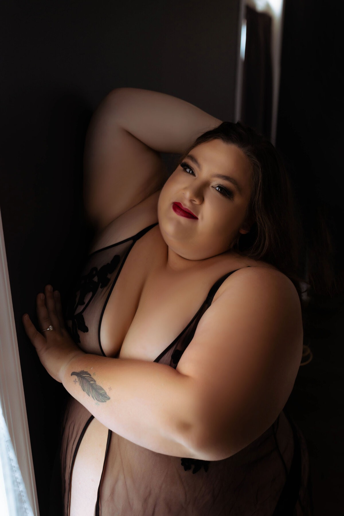 plus size boudoir photo of woman with hand in hair